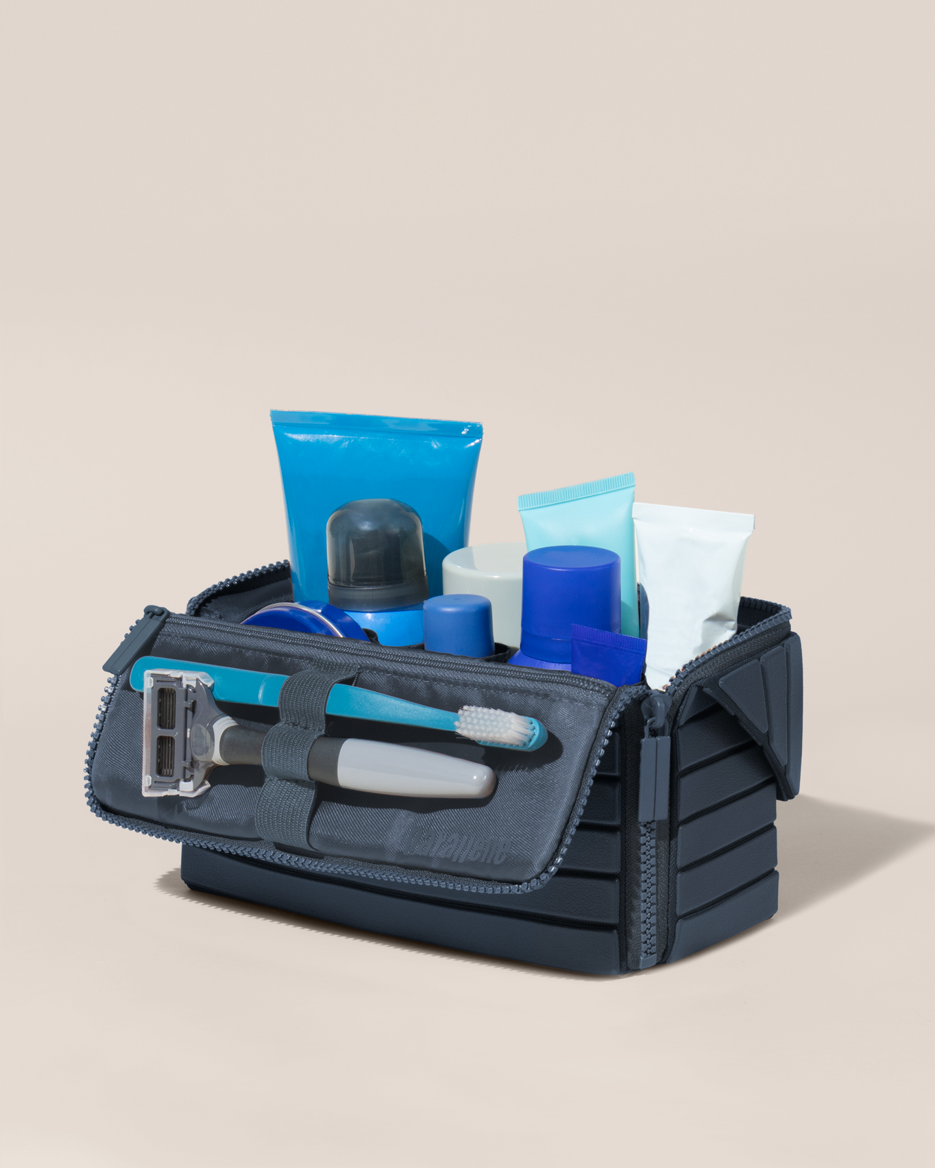 Open Parallelle Medium Indigo (blue) Kit, shown open and packed with grooming essentials like razors, cologne, and skincare. A structured, travel-ready toiletry organizer