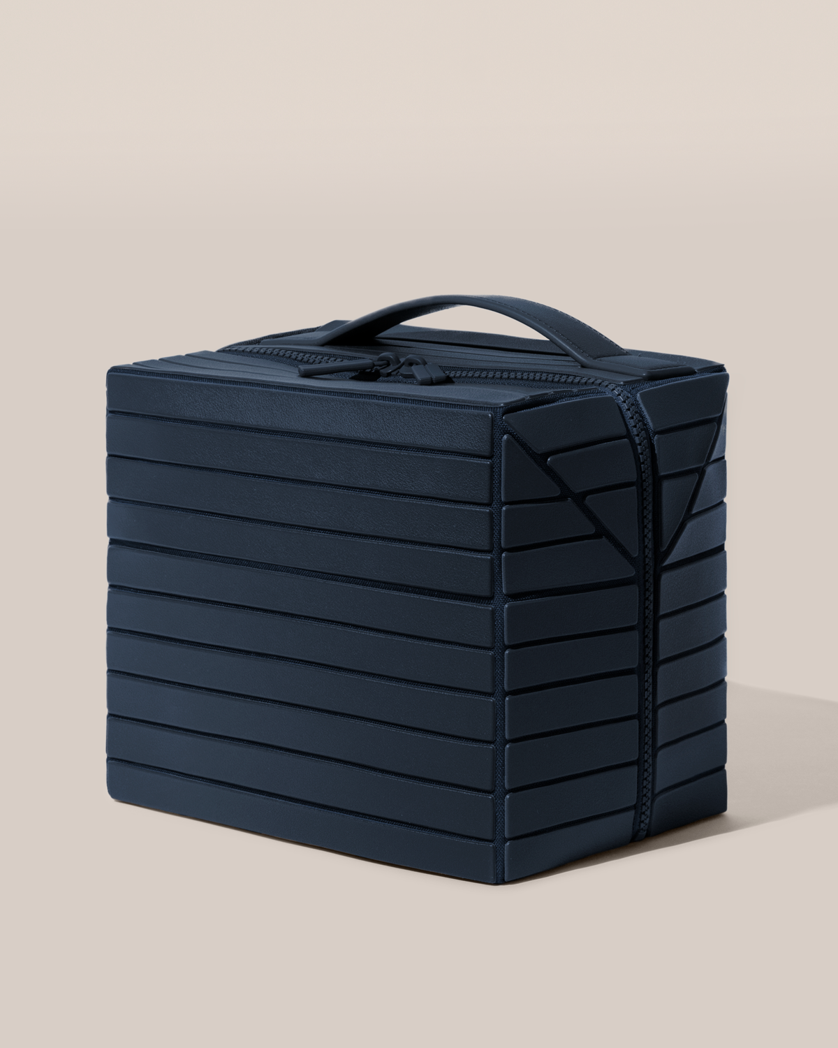 Closed Parallelle Indigo (blue) Kit toiletry bag with a compact, zip-around design and top handle for elevated everyday or travel organization