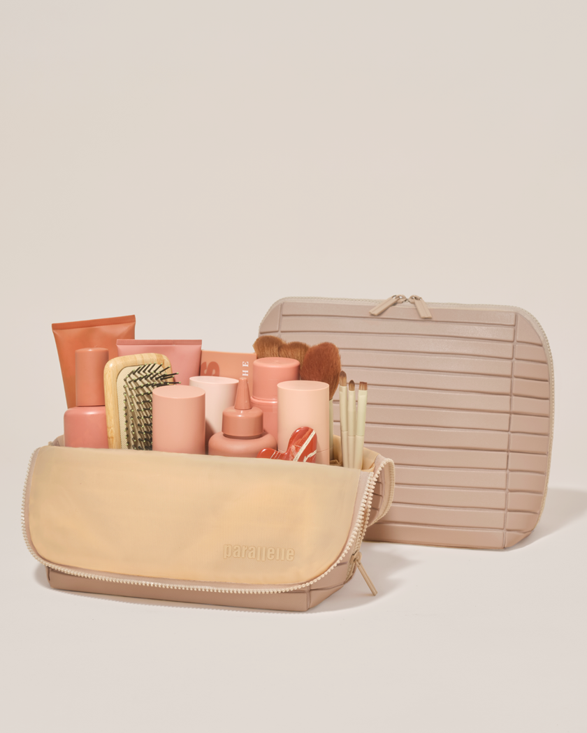 Open and closed Parallelle Large Bisque (white) Traveller makeup bag showing skincare, brushes, and curated travel essentials
