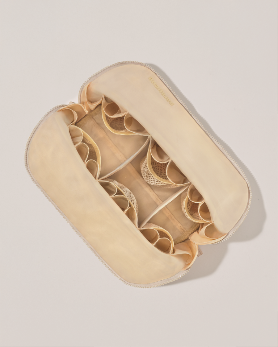 Interior view of Parallelle Large Bisque (white) Traveller makeup bag showing empty pockets, pouches, and elastic holders