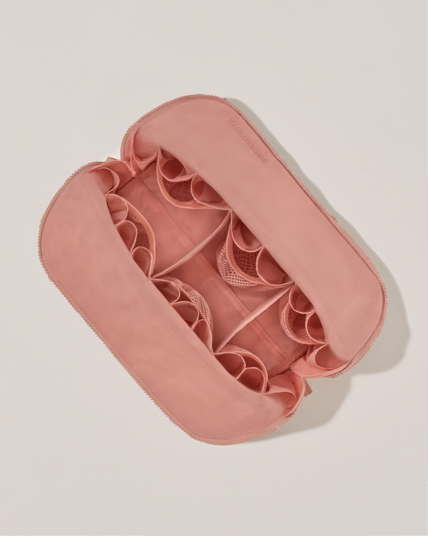 Interior view of Parallelle Large Blush (pink) Traveller makeup bag showing empty pockets, pouches, and elastic holders
