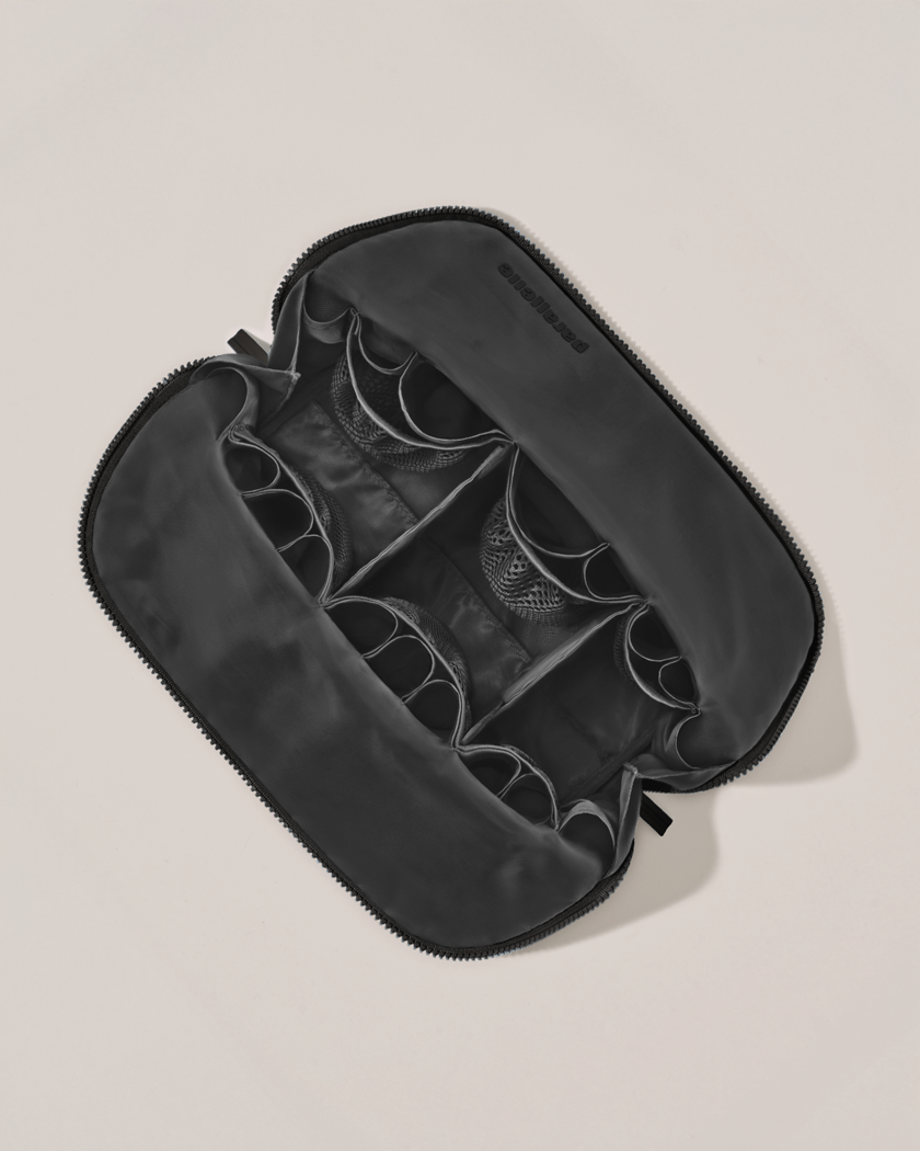 Interior view of Parallelle Large Onyx (black) Traveller makeup bag showing empty pockets, pouches, and elastic holders