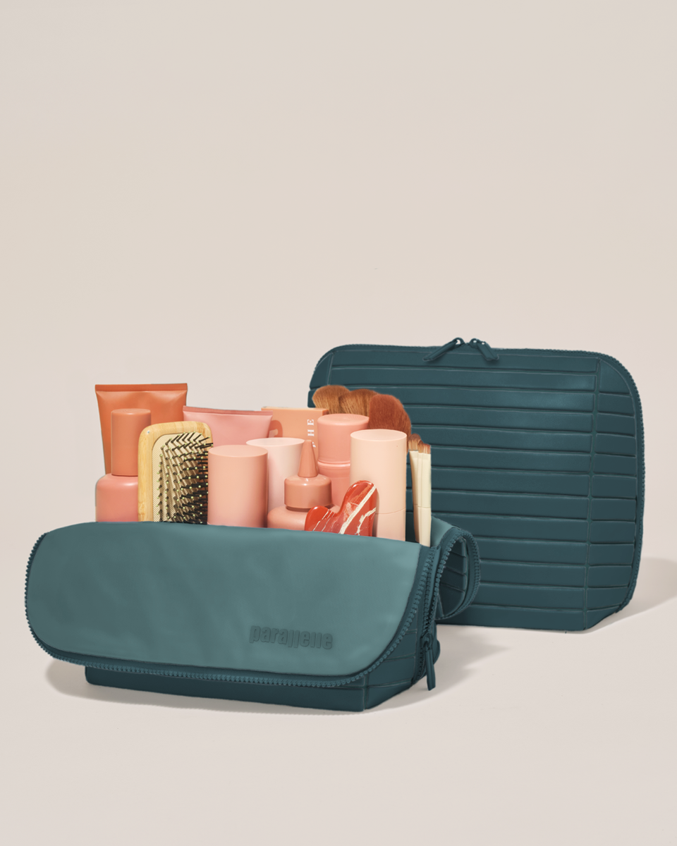 Open and closed Parallelle Large Spruce (green) Traveller makeup bag showing skincare, brushes, and curated travel essentials