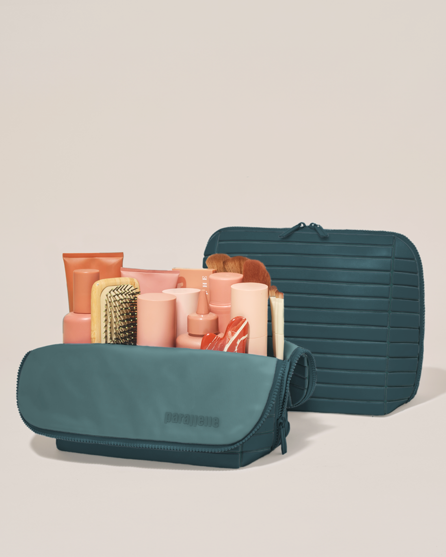 Open and closed Parallelle Large Spruce (green) Traveller makeup bag showing skincare, brushes, and curated travel essentials
