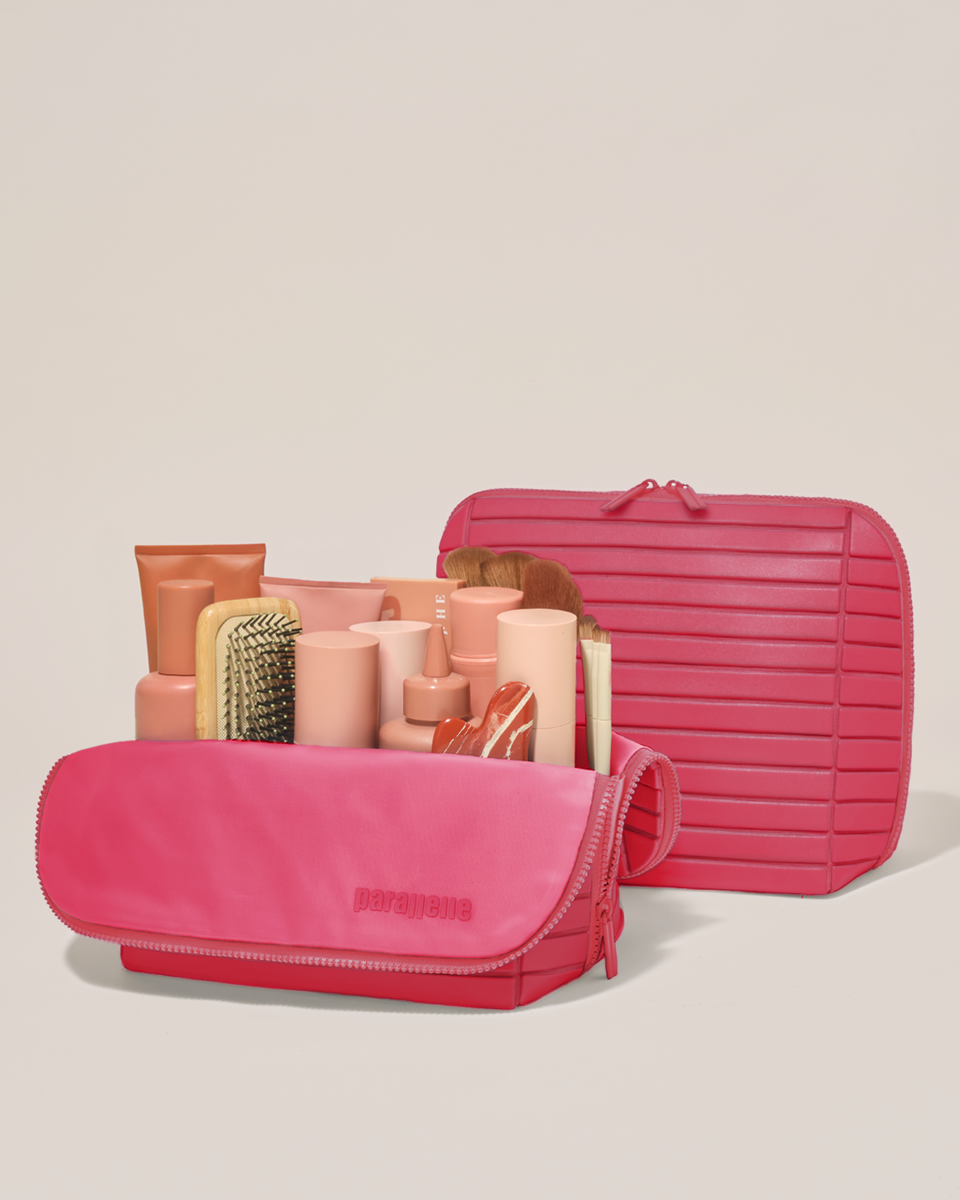 Open and closed Parallelle Large Tart (hot pink) Traveller makeup bag showing skincare, brushes, and curated travel essentials