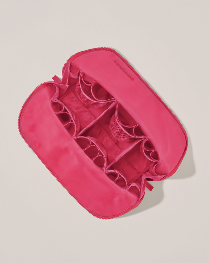 Interior view of Parallelle Large Tart (hot pink) Traveller makeup bag showing empty pockets, pouches, and elastic holders