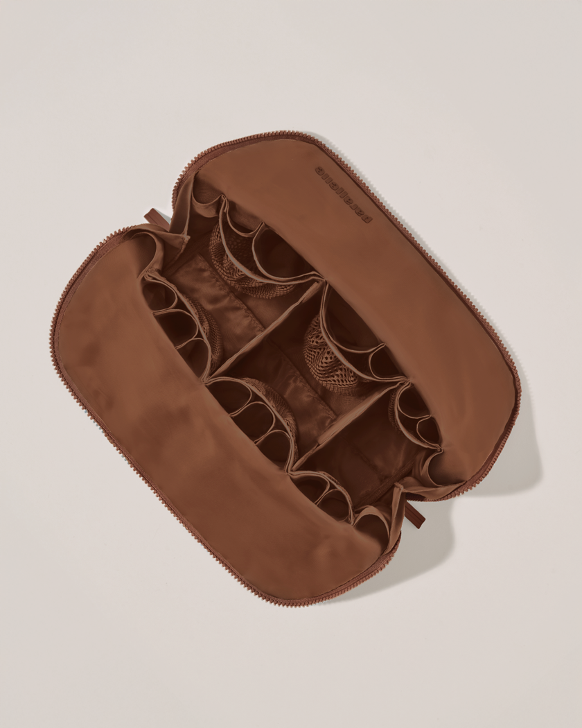 Interior view of Parallelle Large Vicuna (brown) Traveller makeup bag showing empty pockets, pouches, and elastic holders