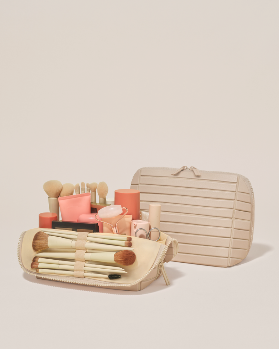 Open and closed Parallelle Medium Bisque (white) Traveller makeup bag showing skincare, brushes, and curated travel essentials