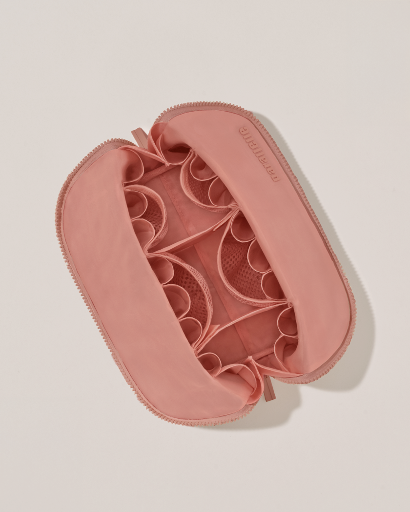 Interior view of Parallelle Medium Blush (pink) Traveller makeup bag showing empty pockets and puches