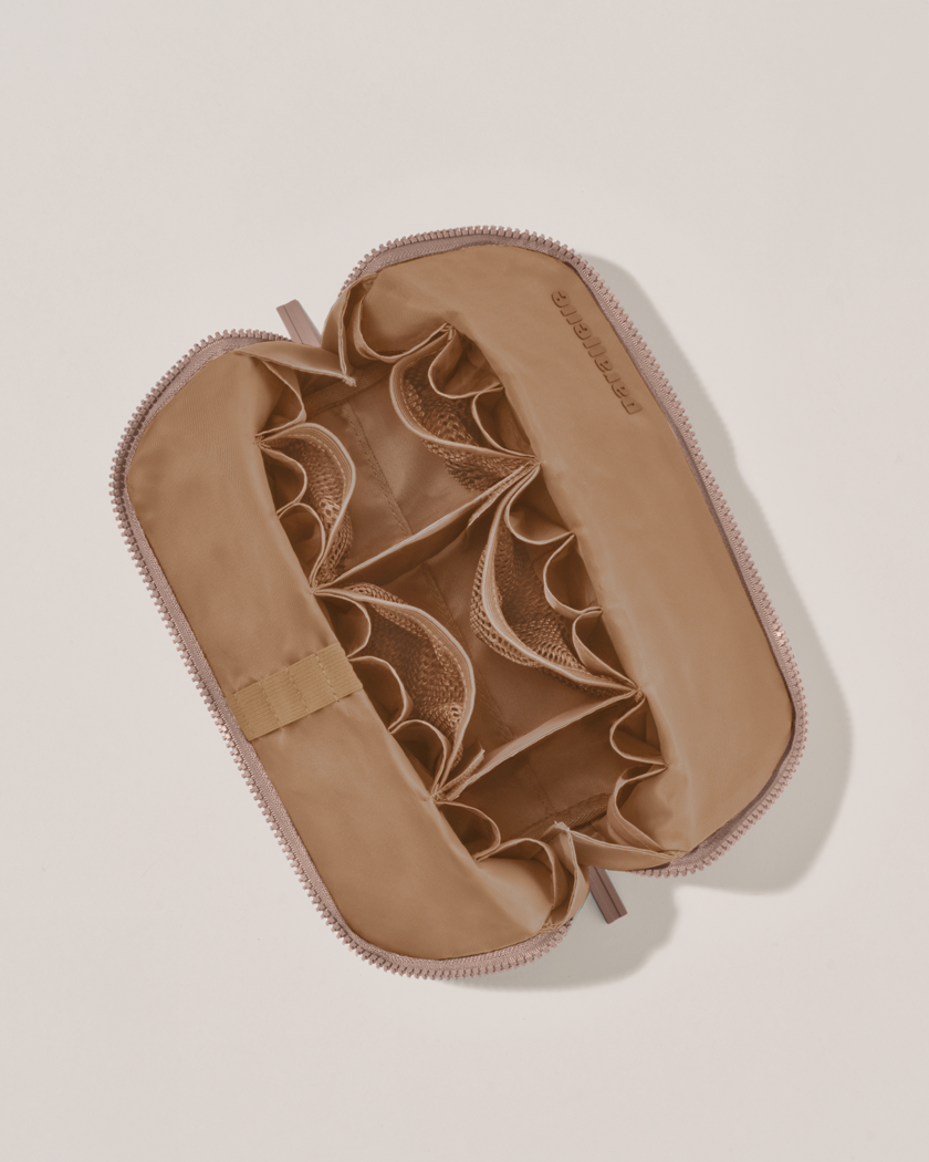 Interior view of Parallelle Medium Bronze Traveller makeup bag showing empty pockets, pouches, and elastic holders