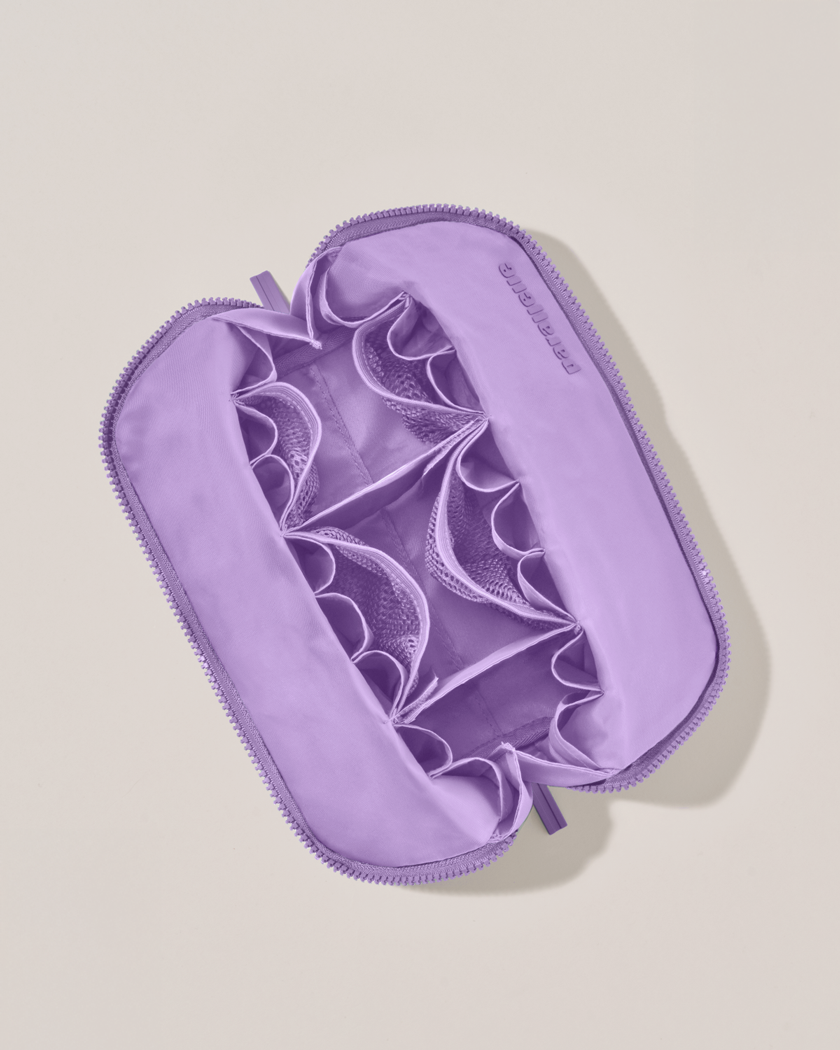 Interior view of Parallelle Medium Lilac (purple) Traveller makeup bag showing empty pockets and pouches