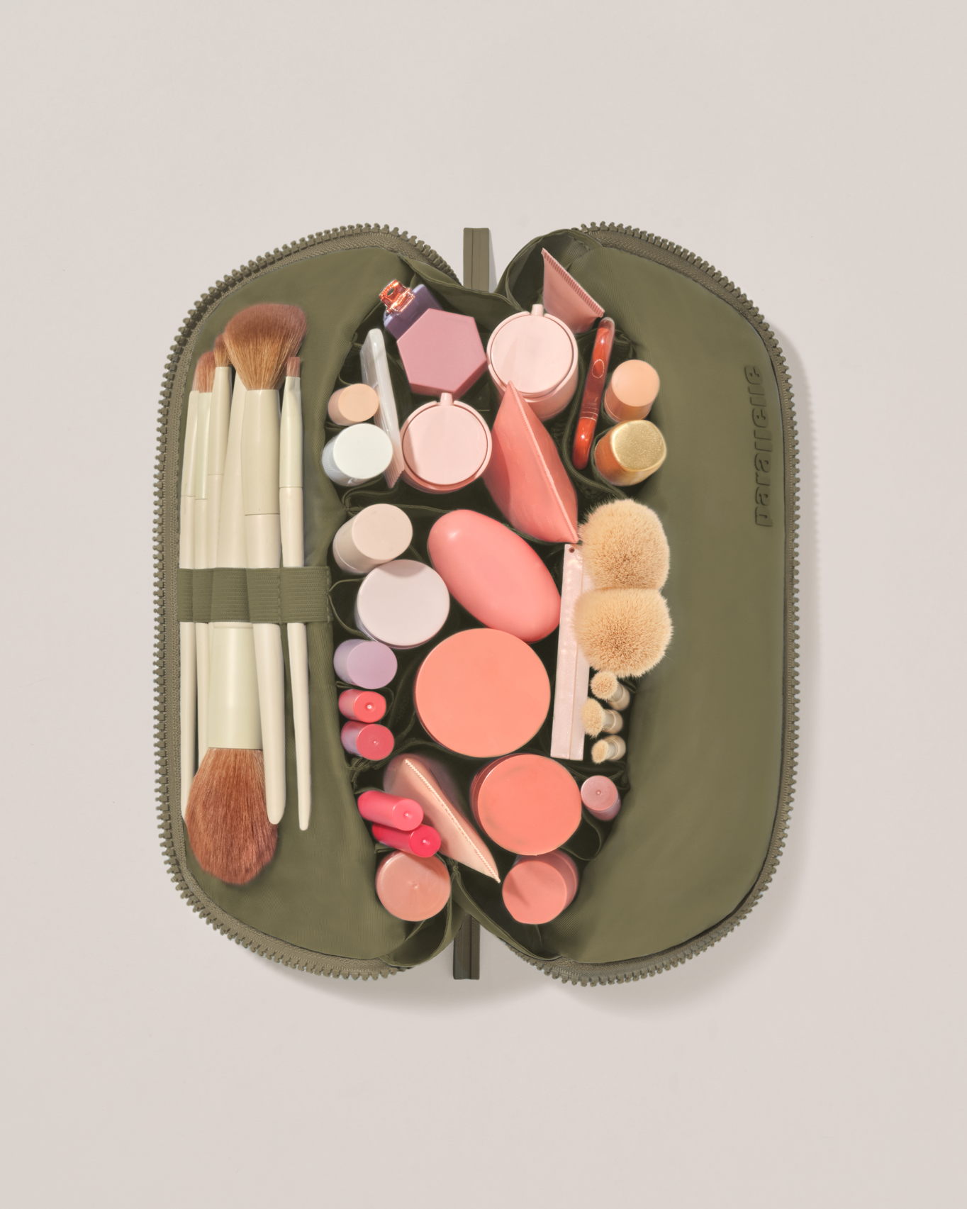 Overhead view of the Medium Olive (green) Traveller makeup bag fully packed with upright beauty products and organized compartments