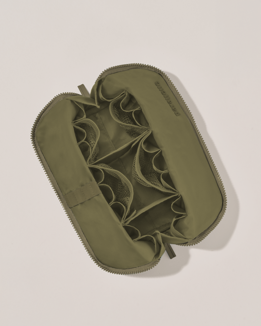 Interior view of Parallelle Medium Olive (green) Traveller makeup bag showing empty pockets, pouches, and elastic holders
