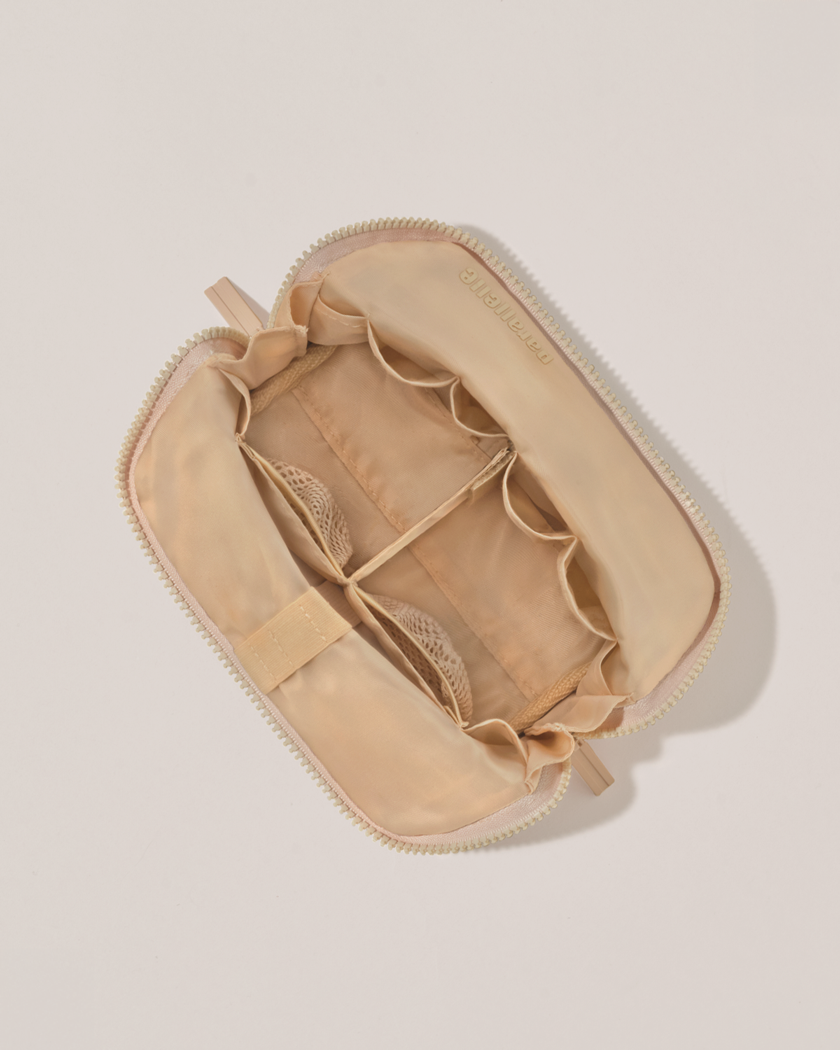 Interior view of Parallelle Small Bisque (white) Traveller makeup bag showing empty pockets, pouches, and elastic holders
