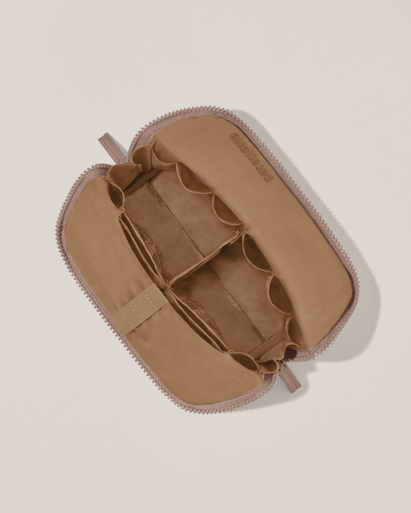 Interior view of Parallelle Small Bronze Traveller makeup bag showing empty pockets, pouches, and elastic holders