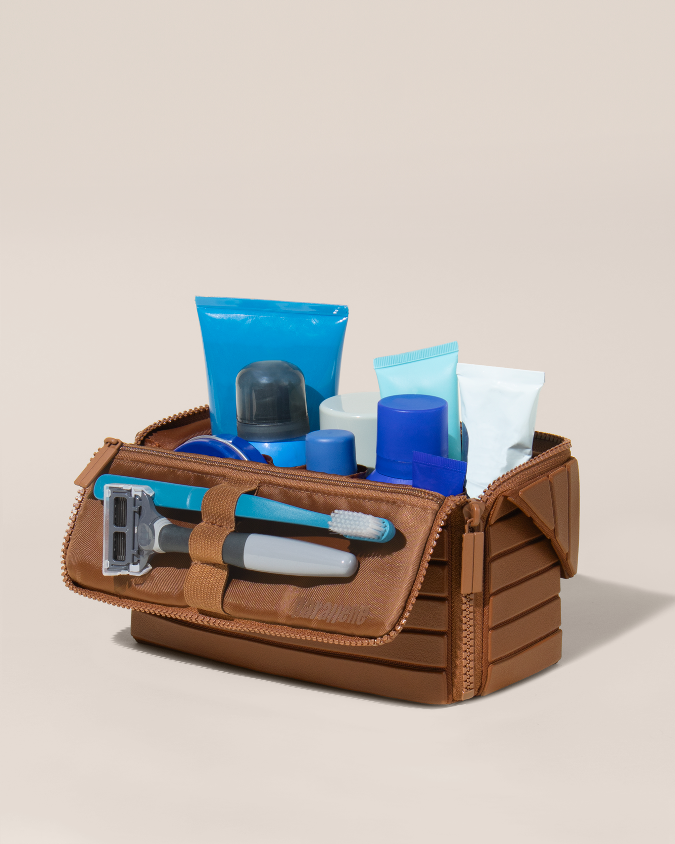 Open Parallelle Medium Vicuna (brown) Kit, shown open and packed with grooming essentials like razors, cologne, and skincare. A structured, travel-ready toiletry organizer