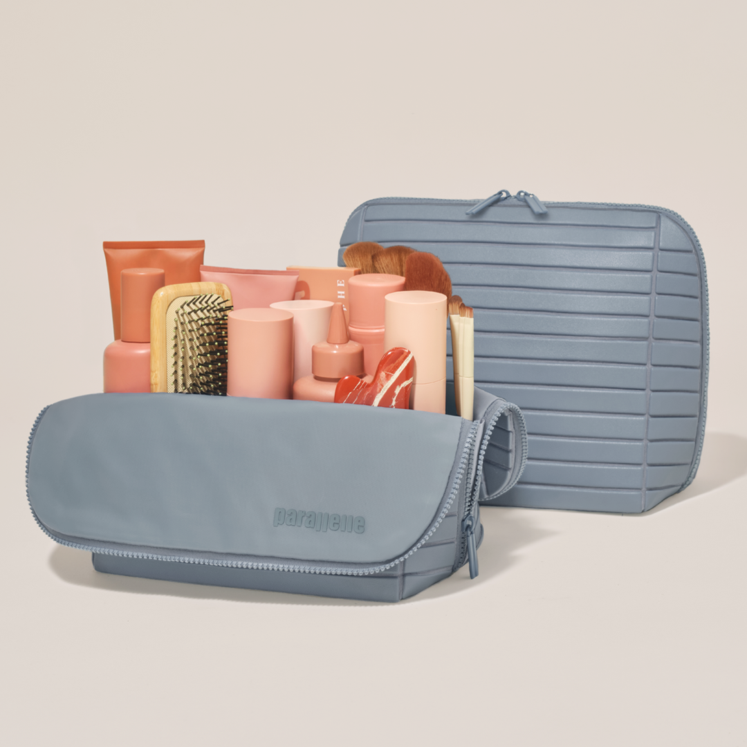 The Large Slate Traveller shown open and closed, packed with tall bottles, skincare, and makeup brushes.