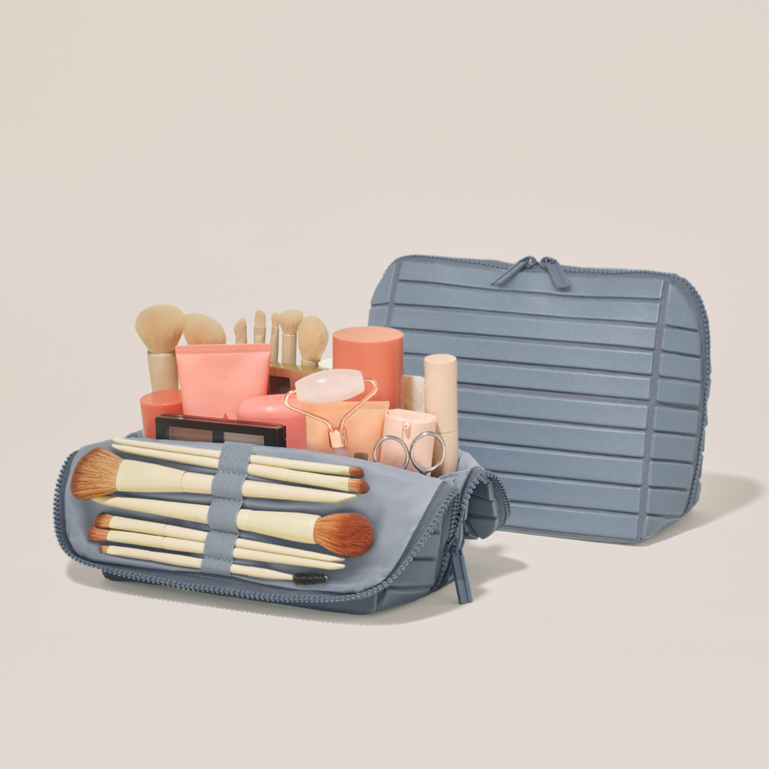 The Medium Slate Traveller shown open and closed, packed with tall bottles, skincare, and makeup brushes in elastic loops
