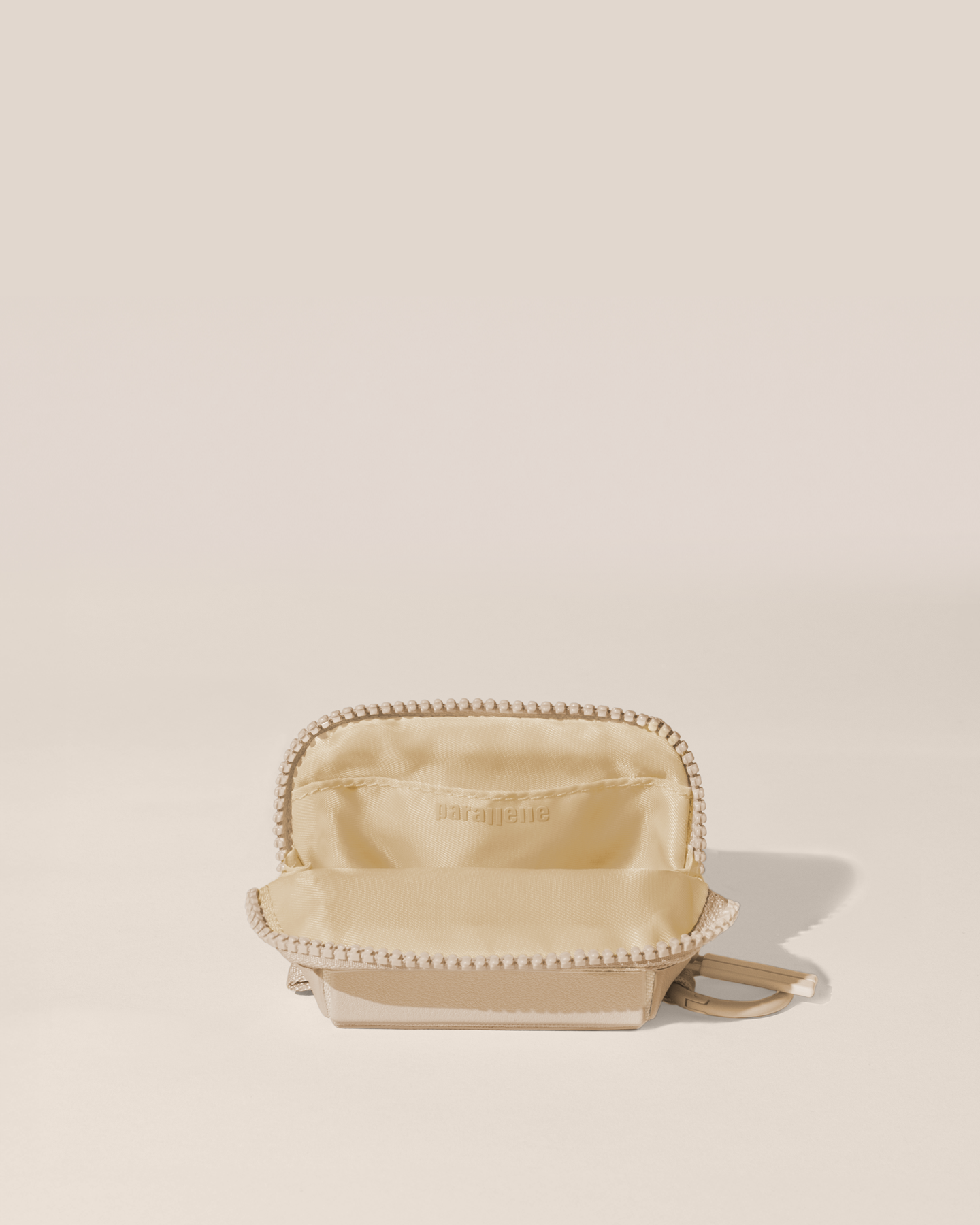 Open view of the Parallelle White (bisque) Traveller Keychain showing the interior, which is perfect for holding small essentials