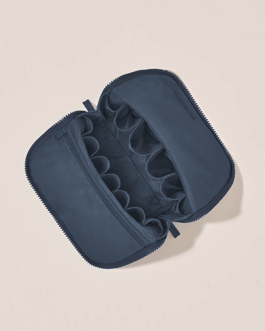 Interior view of Parallelle Indigo (navy) Brush Traveller makeup bag showing empty pockets and pouches