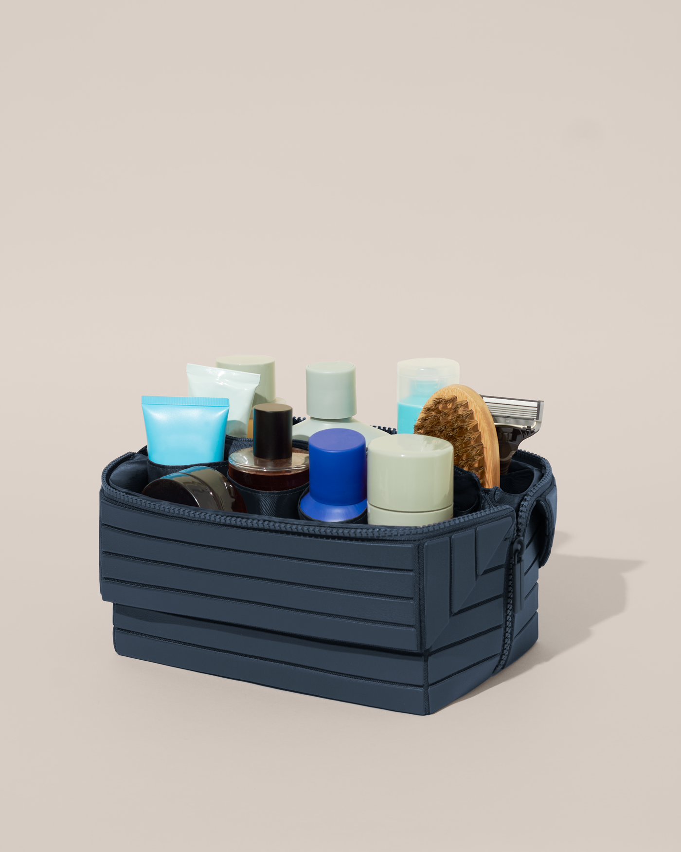 Open Parallelle Indigo (blue) Kit, shown open and packed with grooming essentials like razors, cologne, and skincare. A structured, travel-ready toiletry organizer