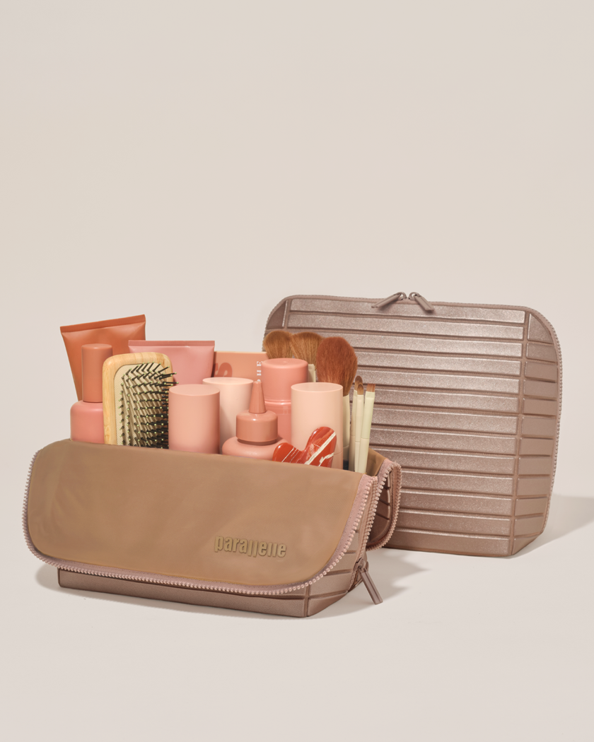 Open and closed Parallelle Large Bronze Traveller makeup bag showing skincare, brushes, and curated travel essentials
