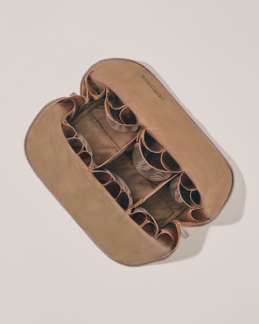 Interior view of Parallelle Large Bronze Traveller makeup bag showing empty pockets, pouches, and elastic holders