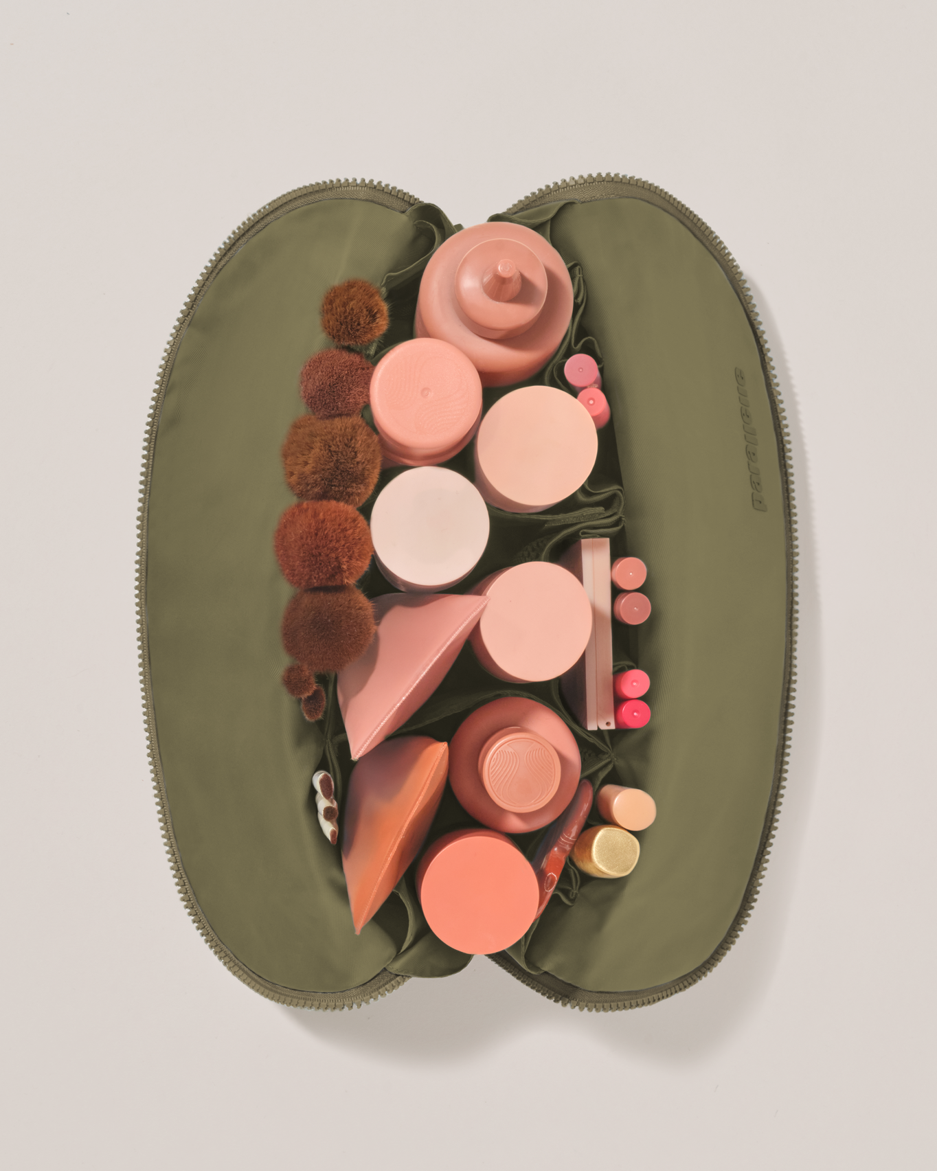 Overhead view of the Large Olive (green) Traveller makeup bag fully packed with upright beauty products and organized compartments