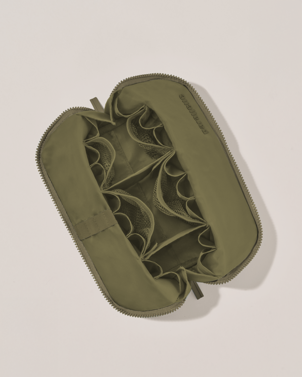 Interior view of Parallelle Medium Olive (green) Traveller makeup bag showing empty pockets, pouches, and elastic holders