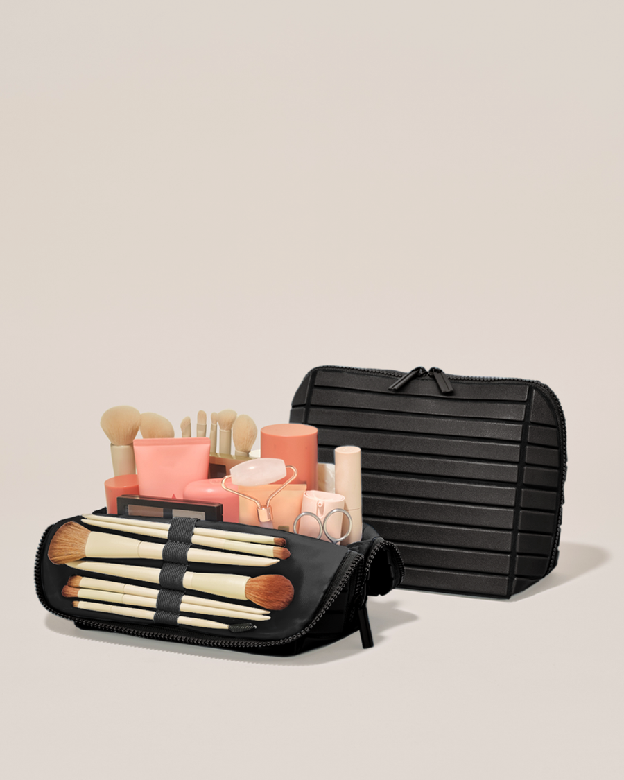 Open and closed Parallelle Medium Onyx (black) Traveller makeup bag showing skincare, brushes, and curated travel essentials