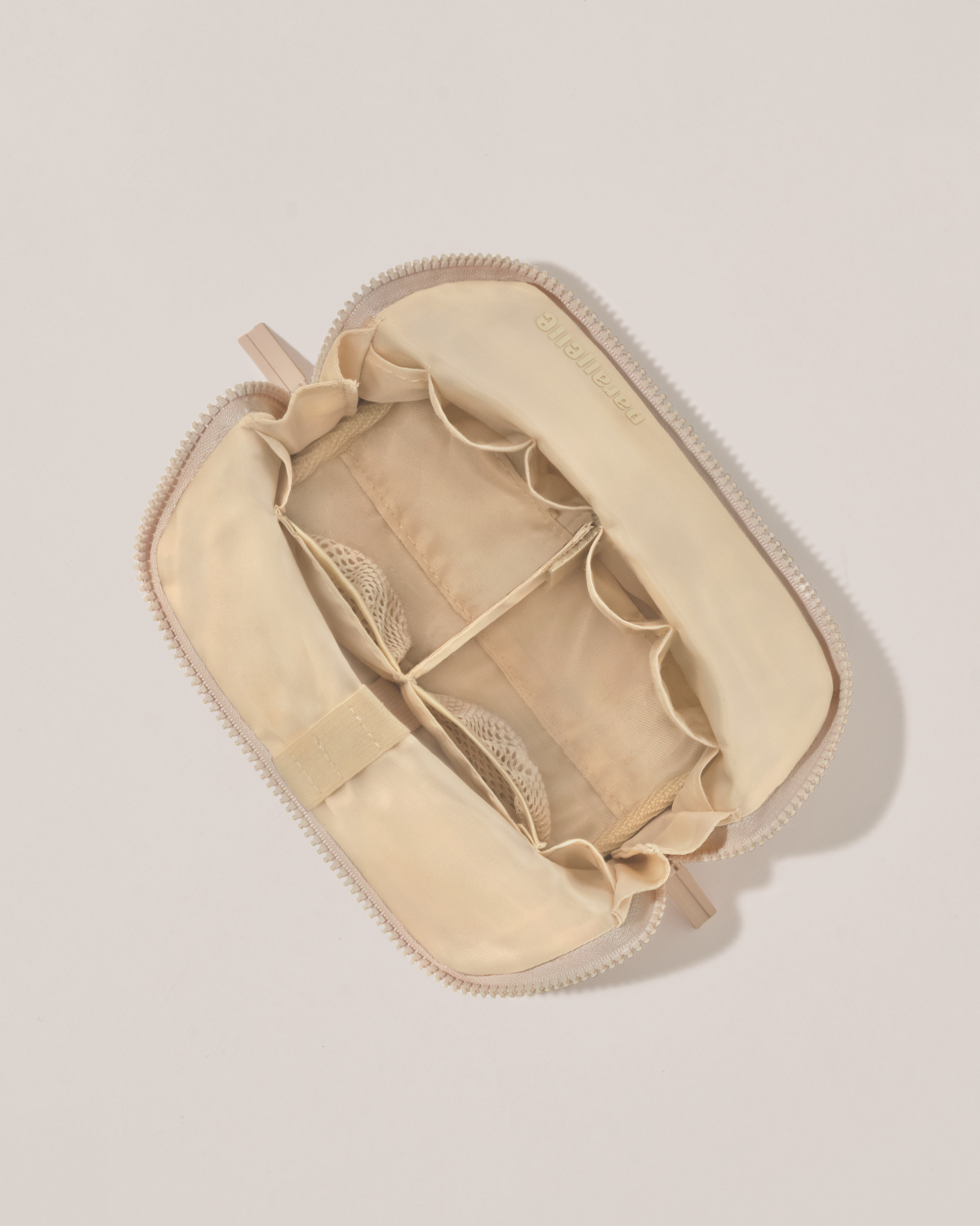 Interior view of Parallelle Small Bisque (white) Traveller makeup bag showing empty pockets, pouches, and elastic holders