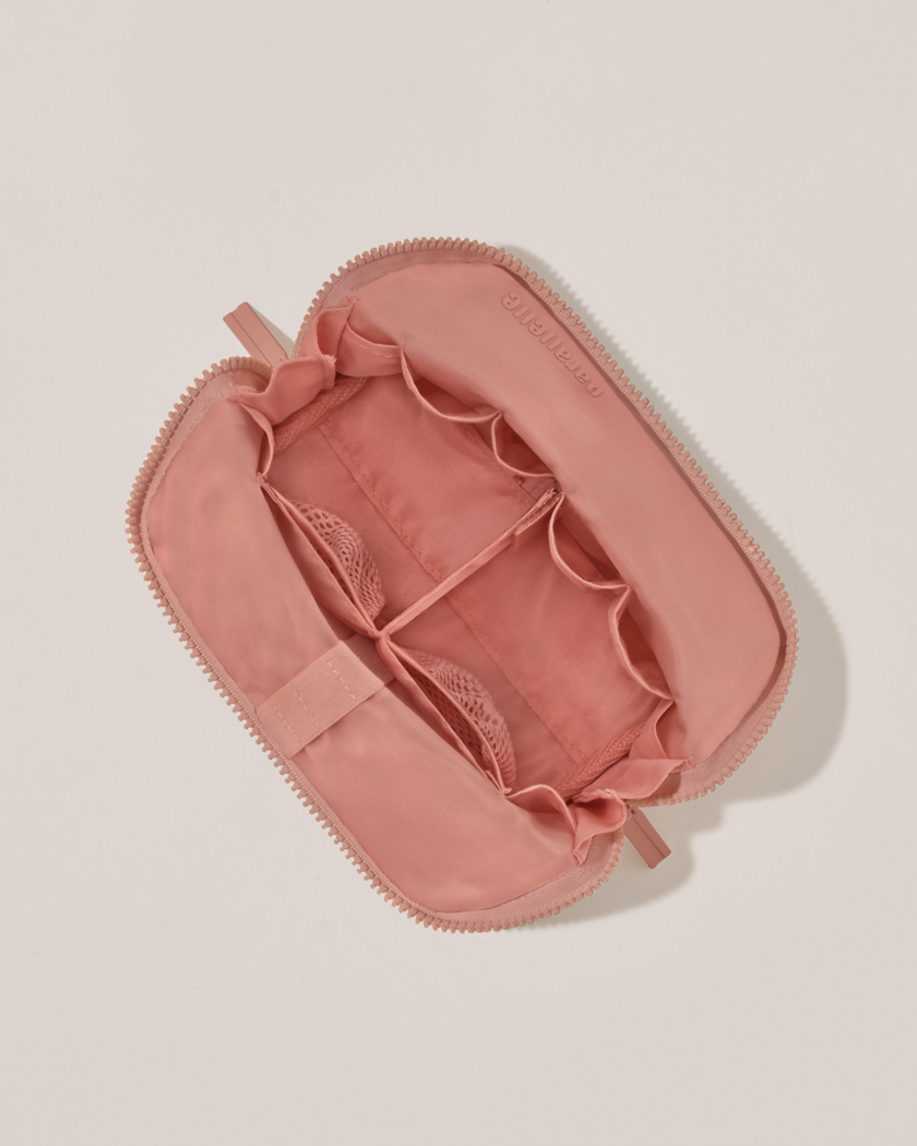Interior view of Parallelle Small Blush (pink) Traveller makeup bag showing empty pockets, pouches, and elastic holders