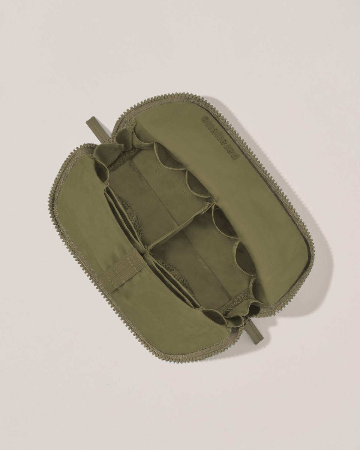 Interior view of Parallelle Small Olive (green) Traveller makeup bag showing empty pockets, pouches, and elastic holders