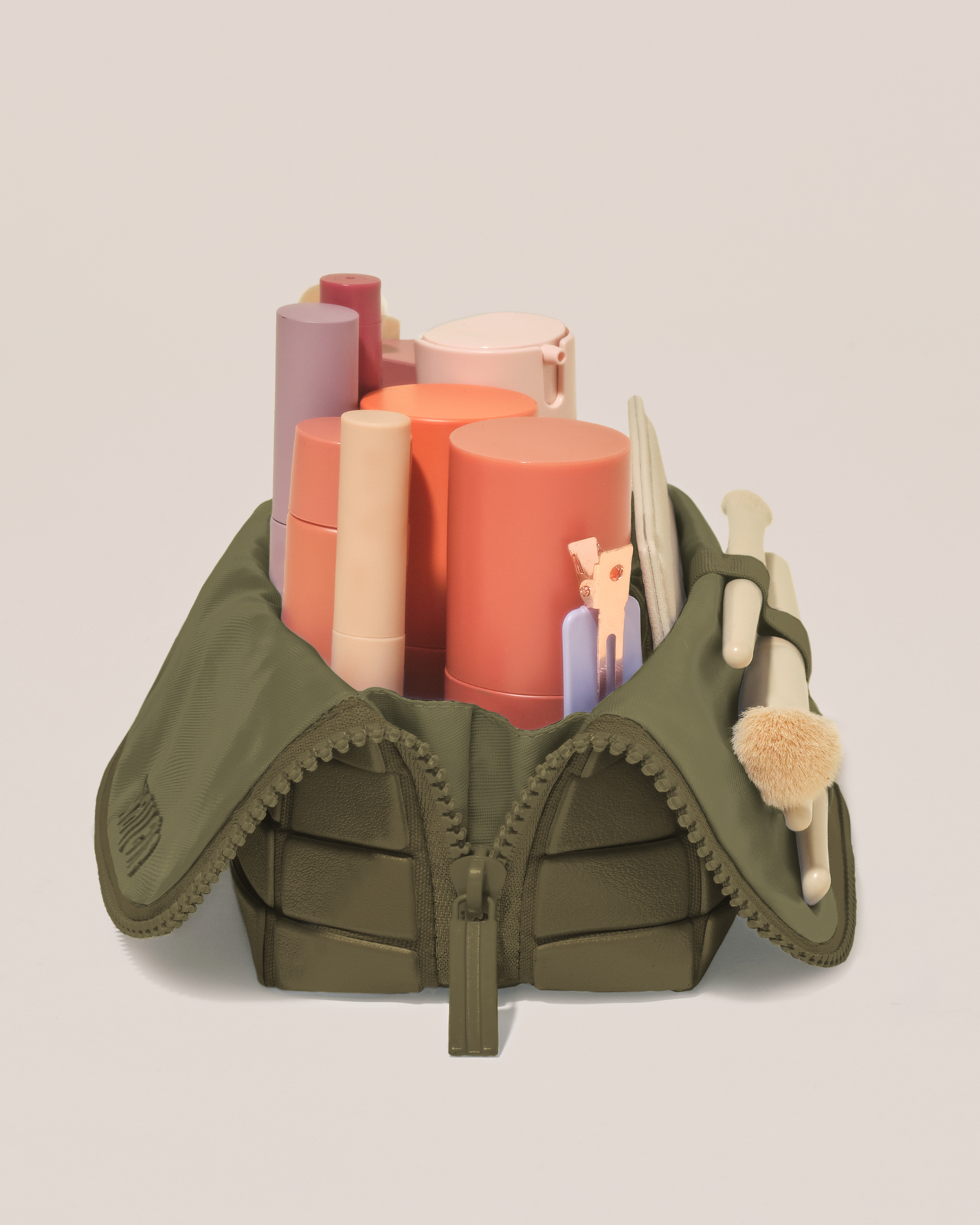 Side profile of the Small Olive (green) Traveller makeup bag filled with beauty essentials standing upright, showing flexible compartment design