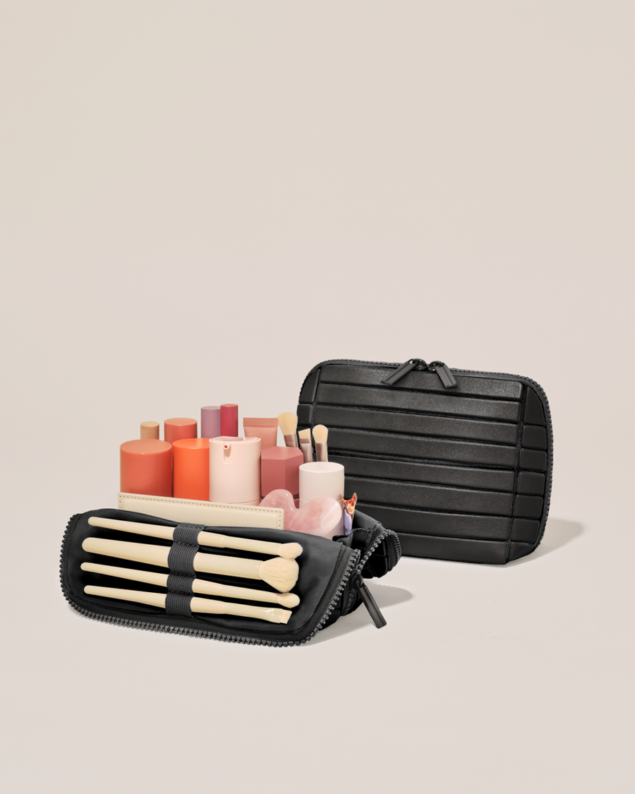 Open and closed Parallelle Small Onyx (black) Traveller makeup bag showing skincare, brushes, and curated travel essentials