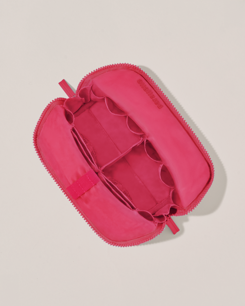 Interior view of Parallelle Small Tart (hot pink) Traveller makeup bag showing empty pockets, pouches, and elastic holders