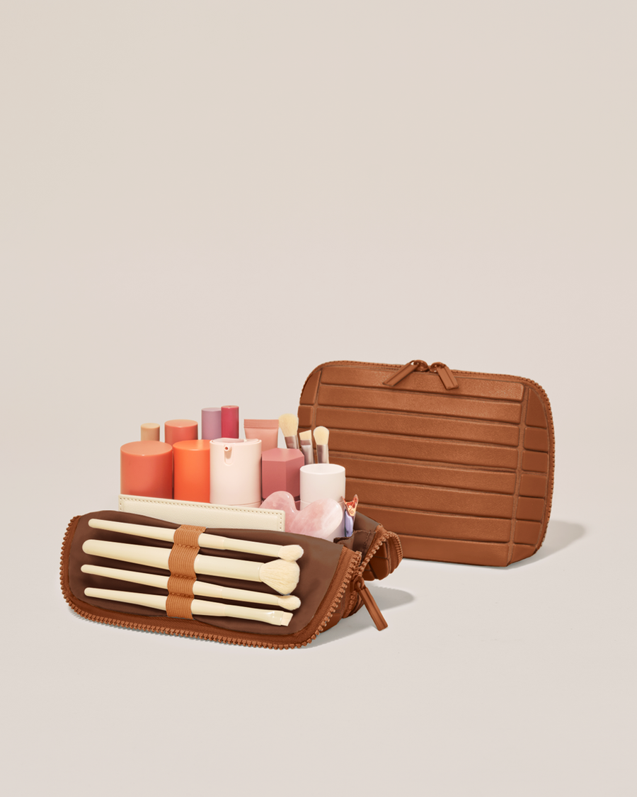Open and closed Parallelle Small Vicuna (brown) Traveller makeup bag showing skincare, brushes, and curated travel essentials
