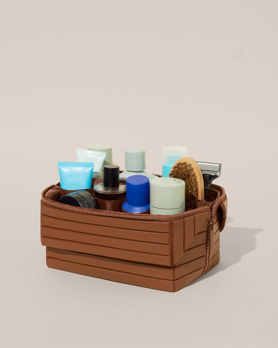 Open Parallelle Vicuna (brown) Kit, shown open and packed with grooming essentials like razors, cologne, and skincare. A structured, travel-ready toiletry organizer