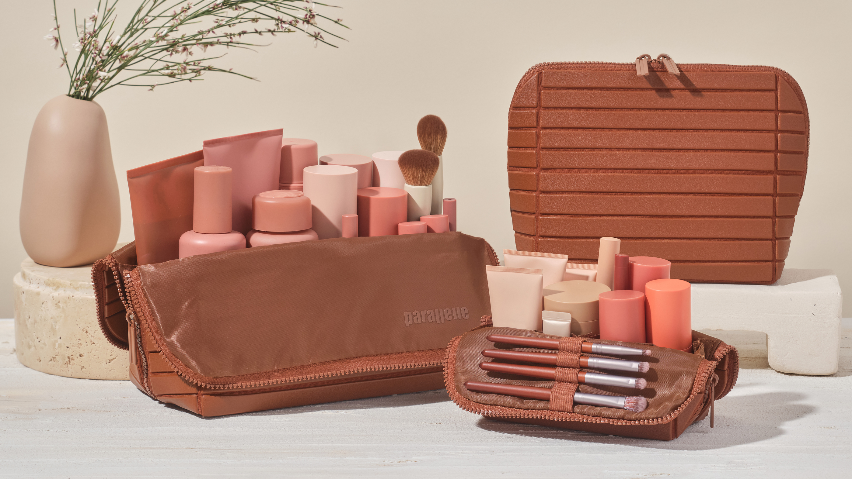 The Small, Medium, and Large Vicuna Travellers, styled with everyday essentials and makeup products.