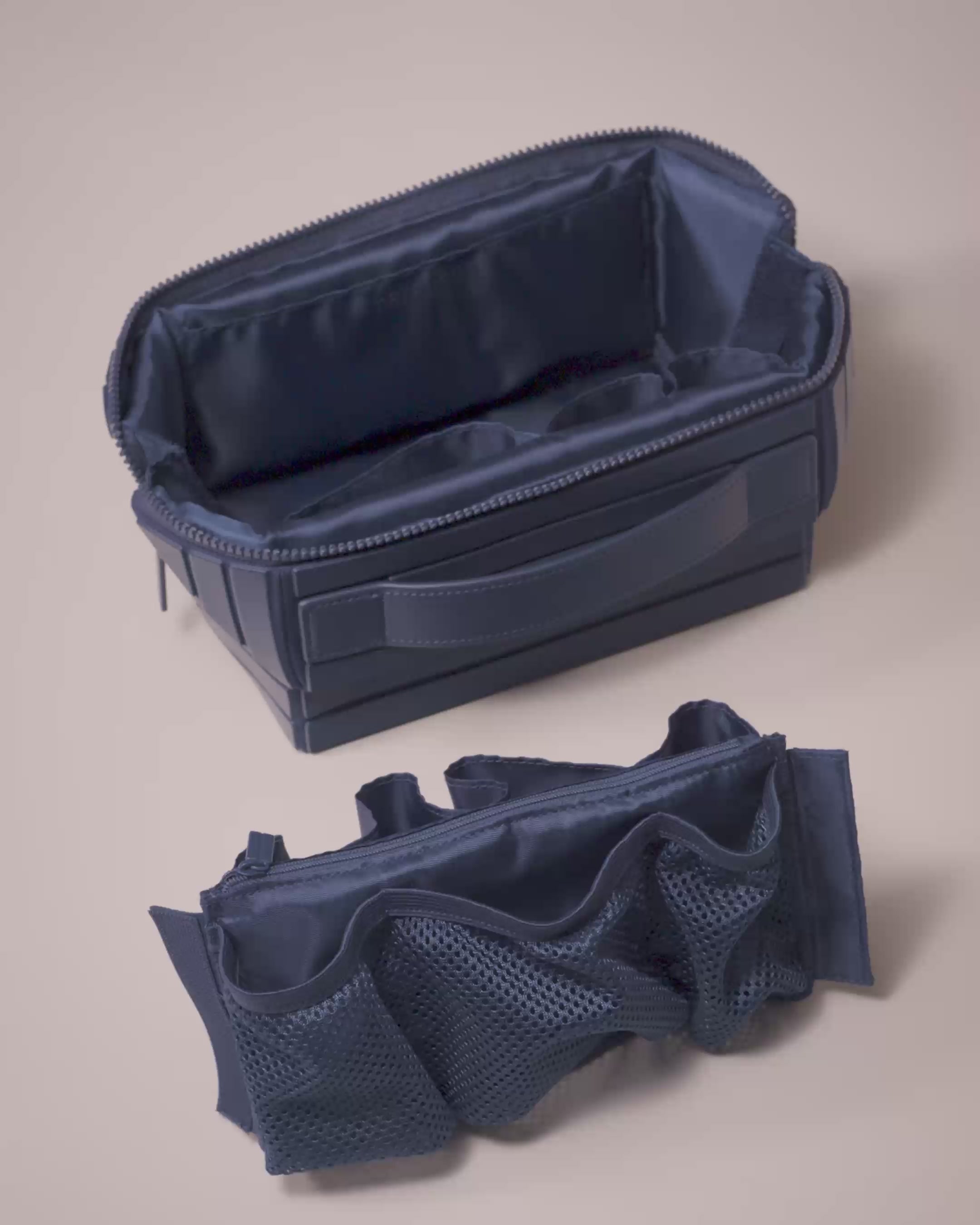 Parallelle Indigo Kit shown with its removable interior insert, featuring mesh pockets and a zip compartment that attaches with Velcro for modular organization