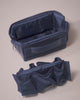 Parallelle Indigo Kit shown with its removable interior insert, featuring mesh pockets and a zip compartment that attaches with Velcro for modular organization