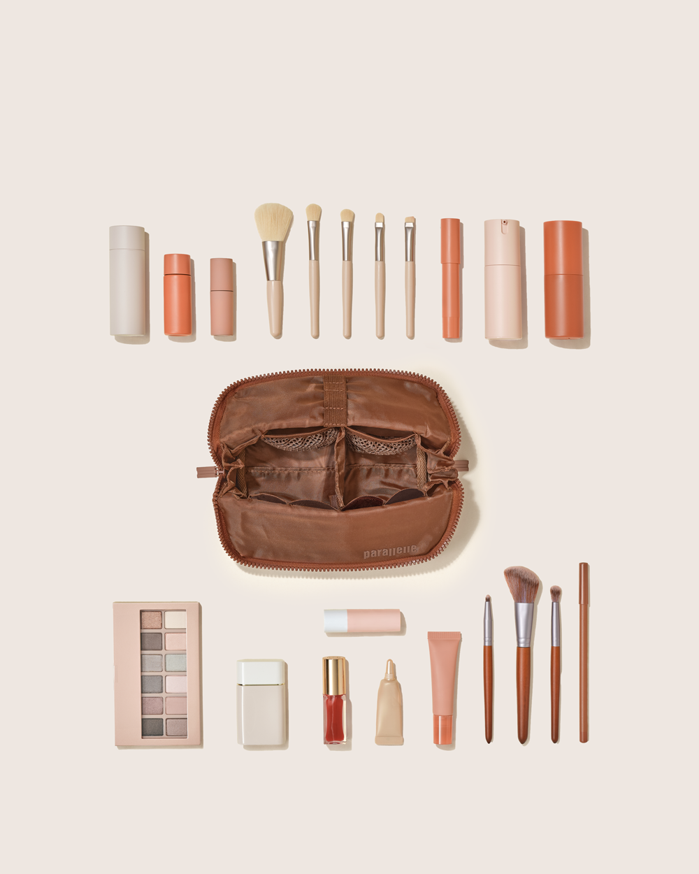 Flat lay of the Small Vicuna Traveller surrounded by makeup brushes, skincare bottles, tubes, and palettes. Compact travel case for beauty essentials.